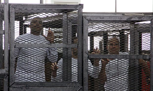 Jailed al-Jazeera journalists Mohamed Fahmy, Baher Mohamed and Peter Greste in a cage