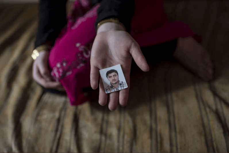 A 14-year-old Syrian refugee in Lebanon holds a photograph of her fiancé. The marriage was arranged by her parents, but the child was unhappy. Credit: Facebook