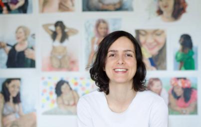 Flavia Bernardes in her studio, surrounded by images from her series of body positive portraits.