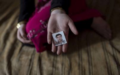 A 14-year-old Syrian refugee in Lebanon holds a photograph of her fiancé. The marriage was arranged by her parents, but the child was unhappy. Credit: Facebook